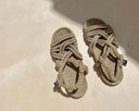 Pair of rope sandals on a sandy surface